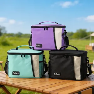 Tre borse termiche isolate in PEVA viola, menta e nere su un tavolo da picnic all'aperto