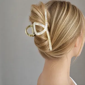 Large iridescent acetic acid hair claw clip shown in a stylish hairstyle