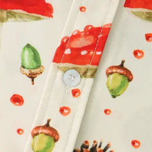 Close-up of men's shirt fabric featuring acorn and mushroom prints with white button.