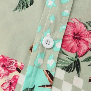 Close-up detail of men's tropical floral shirt with white button and sage green fabric