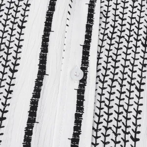 Détail macro d'une chemise de plage blanche pour homme avec rayures noires et motifs de feuilles