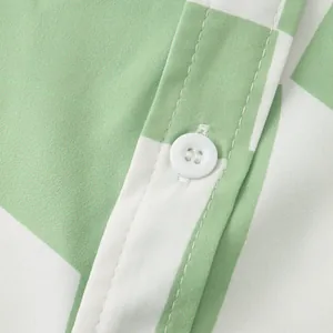 Close-up detail of green and white checkered men's shirt showing button and stitching