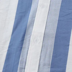 Vue macro d'un tissu de chemise de plage à rayures verticales bleues et blanches avec boutons