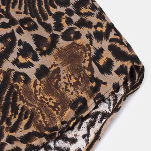 Detailed macro view showing the textured leopard print fabric of the men's casual shirt.