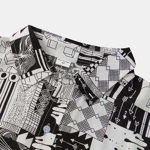 Detailansicht eines Herren-Freizeithemds mit schwarz-weißem geometrischem Muster und Etikett.