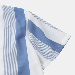 Vue détaillée du tissu rayé bleu et blanc sur une chemise de plage pour hommes