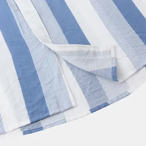 Détail en gros plan de la texture du tissu d'une chemise de plage à rayures bleues et blanches