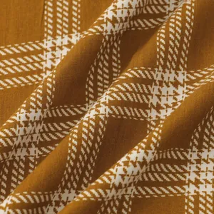 Macro view of brown and white plaid fabric texture for men's short sleeve shirt