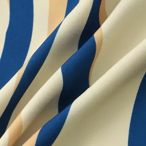Close-up of vertical blue and beige striped fabric with fine diagonal weave texture