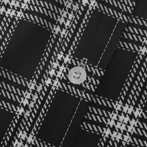 Macro detail of men's black and white checkered shirt fabric with button closure