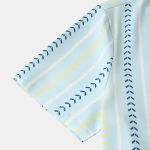 Close-up of men's blue striped shirt sleeve with yellow and navy arrow pattern