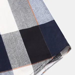 Close-up of the hem stitching and plaid pattern on a men's casual cotton shirt