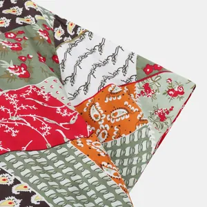 Vue détaillée du motif patchwork et paisley coloré sur le tissu d'une chemise de plage