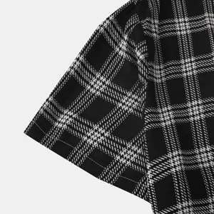 Close-up detail of black and white plaid men's short-sleeved shirt fabric and sleeve hem