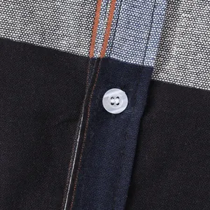 Macro close-up showing the fabric texture and white button of a men's casual shirt