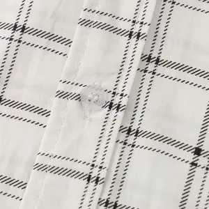 Close-up view of a men's white plaid shirt showing button detail and high-quality fabric texture