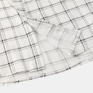 Close-up detail of men's white plaid shirt side vent showing stitching and fabric texture
