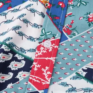 Détail de la patte de boutonnage d'une chemise de plage pour hommes à imprimé patchwork.