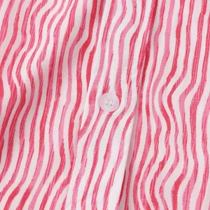 Vue macro de la texture du tissu d'une chemise de plage pour hommes à rayures rouges
