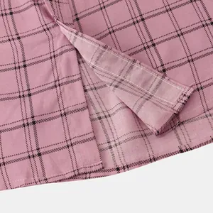 Macro view showing the pink checkered fabric and fine stitching on a shirt sleeve cuff detail