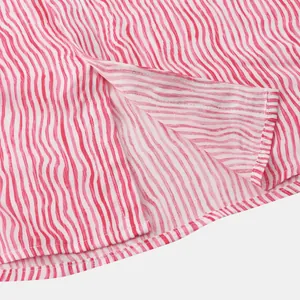 Gros plan sur l'ourlet et la fente latérale d'une chemise rayée rouge pour homme