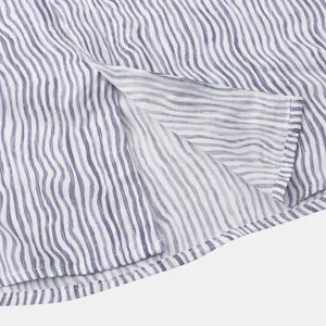 Détail en gros plan du tissu à rayures ondulées violettes sur l'ourlet d'une chemise de plage