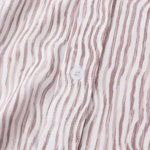 Vue macro détaillée montrant la texture du tissu et le bouton de la chemise d'été rayée