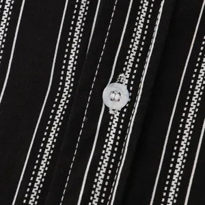 Close-up detail showing the black and white striped fabric and button of a men's shirt