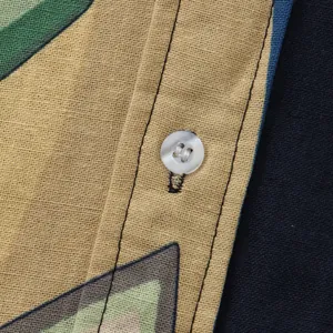 Close-up detail showing the high-quality linen fabric and white button on a men's floral shirt