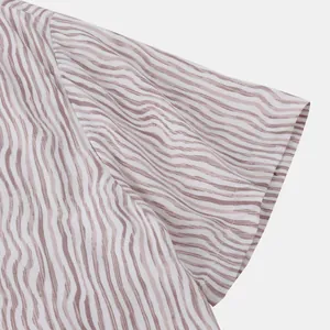 Vue détaillée du motif à rayures ondulées et des coutures sur la manche d'une chemise de plage
