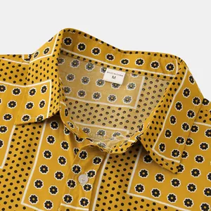 Detailed close-up of yellow floral and polka dot pattern shirt collar with size M label