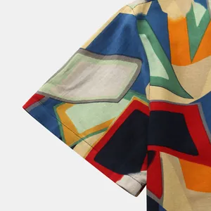 Detailed close-up of vibrant geometric abstract pattern on men's short sleeve shirt