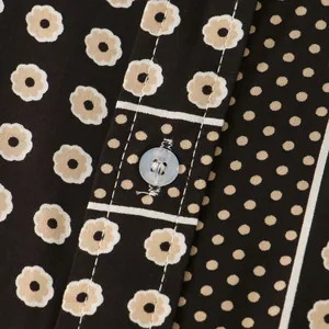 Close-up of pattern and button detail on men's floral and polka dot shirt