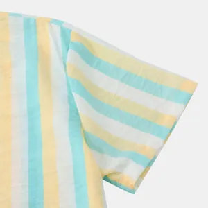 Détail de la manche d'une chemise d'été rayée jaune, bleu et blanc pour homme.