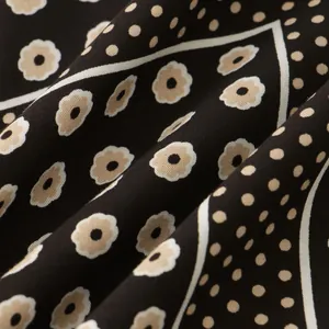 Detailed macro shot of dark floral and polka dot patterns on premium men's shirt fabric texture