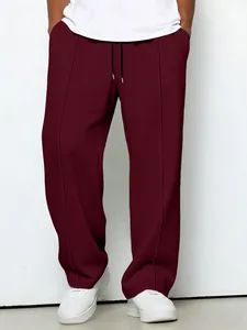 Detailed view of men's burgundy waffle knit drawstring trousers with straight leg fit