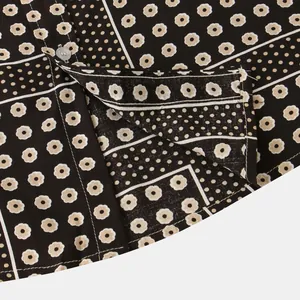 Close-up of floral and dot pattern on men's short-sleeved shirt with a transparent button.