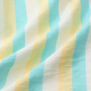 Gros plan sur la texture d'un tissu léger à rayures jaunes et cyan pour chemise de plage