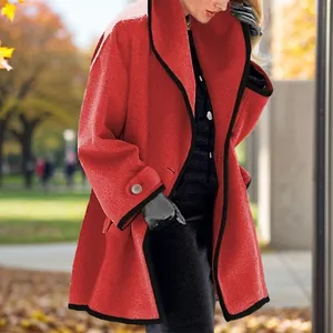 Detail of red women's wool coat featuring elegant black contrast piping and buttons