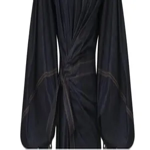 Close-up detail of vintage denim dress featuring tie waist and lantern sleeves