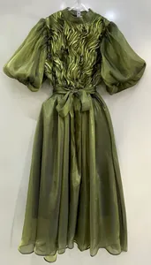 Vista detallada de un elegante vestido verde oliva con mangas abullonadas y brillo metálico