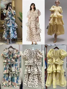 Detail view of printed and solid tiered maxi dresses with puff sleeves and ruffles