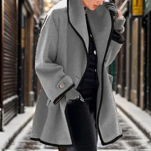 Elegant gray winter coat for women with black piping detail shown in snowy city scene
