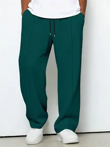 Close-up of men's dark green waffle knit trousers showing the texture and drawstring detail