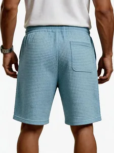 Detailansicht der Rückseite blauer Herren-Freizeitshorts mit Waffelstruktur und Tasche