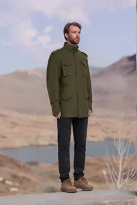 Chaqueta militar verde para hombre modelada en un paisaje de montaña muy sereno