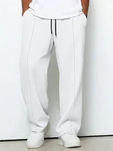 Detail view of men's white waffle knit drawstring pants with a loose straight-leg fit.