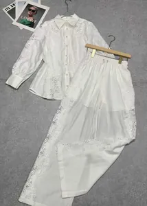Detailed layout of white lace shirt and wide-leg trousers set with intricate embroidery