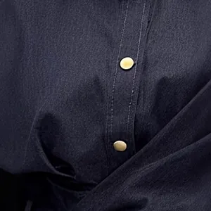 Close-up detail of navy blue denim dress fabric with decorative golden metal buttons
