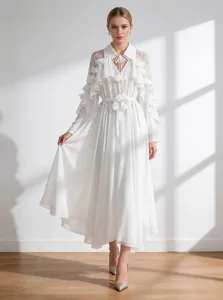 Elegant white tiered ruffle maxi dress with long sleeves and chic tie-waist detail